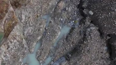 Alp dokusu ve deseni. Ushuaia, Tierra del Fuego, Patagonya Arjantin 'deki küresel ısınma nedeniyle kayalık dağa doğru inen hava manzarası, turkuaz su göletleri ve eriyen buzullar Vinciguerra Buzulu' nun buz sahası.