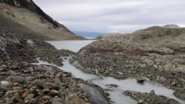 Andes Cordillera 'nın yüksek dağlık arazisi. Yazın Buzul Vinciguerra, Tierra del Fuego, Patagonya Arjantin 'de kayalık dağların tepesinden akan eriyen buzulların ve derelerin manzarası.