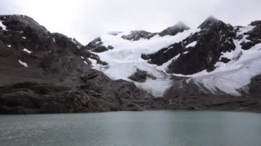 Arjantin 'in Tierra del Fuego kentindeki And Dağları' ndaki buzul Vinciguerra manzarası. Turkuaz renkli su gölü, kayalık dağ tepesi, dağ zirvesinde kar ve buzullu buz..