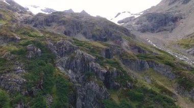 Alp manzarası. Jeoloji. Andes kordillerasındaki kayaların, uçurumların, ormanın ve dağın tepelerinin havadan görüntüsü. Ushuaia, Tierra del Fuego, Arjantin 'deki güzel kaya ve orman dokusu ve renkleri.