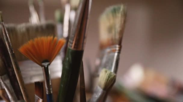 年轻的女画家手从一个有许多不同尺寸和风格的画笔的容器里抓起画笔的场景 — 图库视频影像