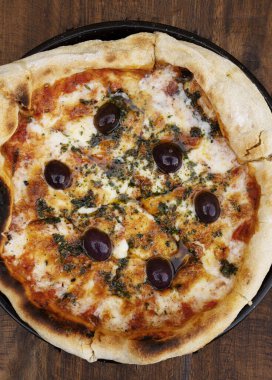 Geleneksel pizza. Domates soslu mozzarella peynirli pizza, siyah zeytin ve ahşap masada taze kekik otu..