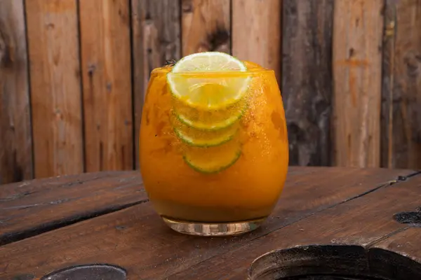 A passion fruit daiquiri drink on the wooden table.
