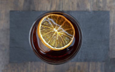 Kokteyller. Negroni alkollü içeceğinin en üst görüntüsü, kurumuş portakal dilimli..