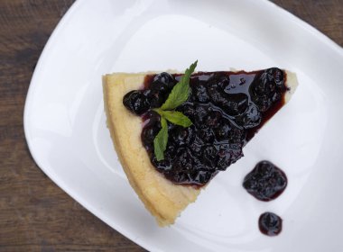 Tatlılar. Masanın üzerinde beyaz bir tabakta peynirli ve dutlu peynirli peynirli cheesecake 'in üst görüntüsü.. 