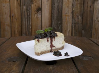 Tatlılar. Masanın üzerinde beyaz bir tabakta peynirli ve dutlu peynirli peynirli cheesecake 'in yakın görüntüsü.. 