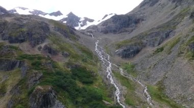 Alp manzarası. Yokuş aşağı akan buzul su akıntısının havadan görüntüsü. Ushuaia, Tierra del Fuego, Patagonya Arjantin 'in yanı sıra uçurumlar, dağ zirveleri, orman ve yürüyüş yolları..
