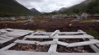 Çevresel hasar. Terk edilmiş doğal turba bataklık sömürüsü fabrikası manzarası. Ushuaia, Patagonya 'daki kırmızı yosun tarlası Sphagnum magellanicum, orman ve And Dağları, Arjantin.