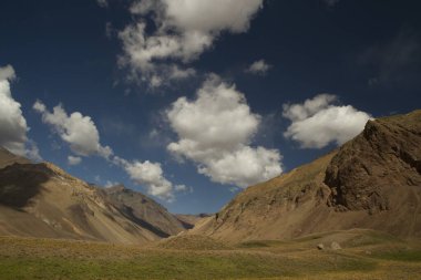 Vadinin, dağların ve sonbahar otlaklarının güzel manzarası. Derin mavi gökyüzünün altında, bulutlar ve gölgeleri çayırda..