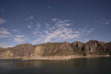 Göl manzarası ve çöldeki kayalık uçurumlar.