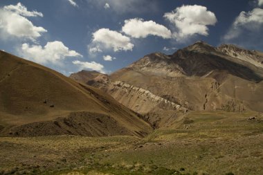 Altın çayır, vadi ve kayalık dağların manzarası. 