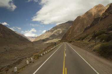 Kırsal yol. Aconcagua 'ya giden yoldaki yüksek dağlarda asfalt karayolu boyunca seyahat ediyor..