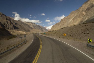 Seyahat et. Kırsal yol. Dağlar boyunca kıvrımlı asfalt yol ve Mendoza, Patagonya 'daki Aconcagua yolunda çöl.. 