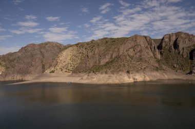 Göl manzarası ve çöldeki kayalık uçurumlar.