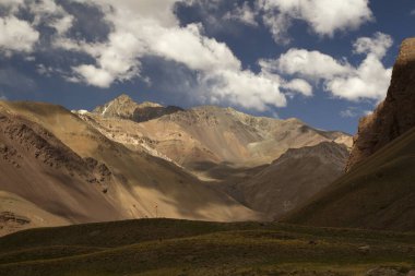 Sonbaharda dağların ve altın vadi çayırlarının manzarası bulutlu mavi bir gökyüzünün altında.. 