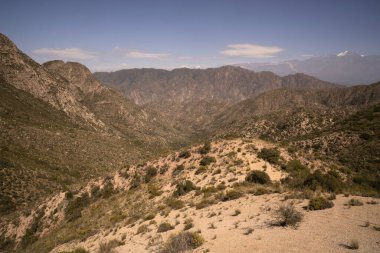 Vadinin manzarası, dağın tepesinden çayır ve tepeler, güneşli bir günde mavi bir gökyüzünün altında.