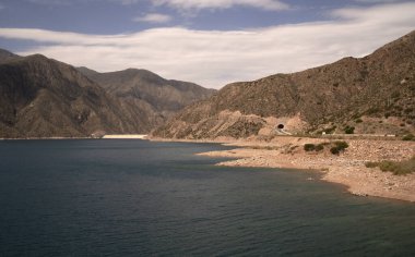 Mavi su gölü manzarası, kırmızı kum çölü ve Potrerillos, Mendoza 'daki kurak dağlar.. 