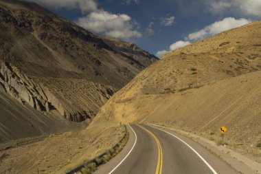 Seyahat et. Arjantin 'in başkenti Mendoza' daki Aconcagua Dağı 'na giden sarı dağlarda, asfalt yol boyunca ilerliyoruz..  