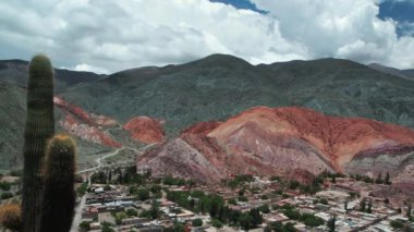 Purmamarca, Jujuy, Arjantin 'deki ünlü Seven Colors Hill' in zaman aşımı. Köyün manzarası, renkli dağlar, dev kaktüsler ve dramatik hareket eden bulutlar.. 