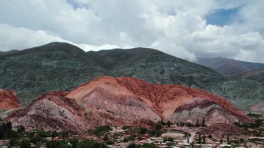 Purmamarca, Jujuy, Arjantin 'deki ünlü Seven Colors Hill' in zaman aşımı. Bulutlar dağda gölgeler ve şekiller oluşturarak geçer. Dağın eteğinde şehri görebiliriz..
