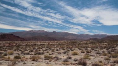 Pan of the desert under a dramatic cloudy sky.