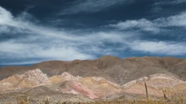Altiplano. Los Cardones Ulusal Parkı, Salta, Arjantin 'de renkli bir tepenin, çölün, dev kaktüsün ve dramatik gökyüzünün zaman kayması.. 