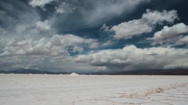 Altiplano doğal tuz tarlalarını tarıyorum. Maden işçilerinin yaptığı küçük tuz dağlarını takdir edebiliriz. Görkemli bulutları olan derin mavi gökyüzü eşsiz bir manzara yaratır..