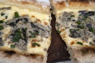 Mozzarella peynirli dilimlenmiş pizza, yeşil soğan ve mantar..