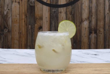 Tropik kokteyller. Bardakta buzlu, limonlu ve şekerli geleneksel bir Caipirinha manzarası.. 