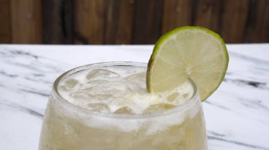 Tropik kokteyller. Bardakta buzlu, limonlu ve şekerli geleneksel bir Caipirinha manzarası.. 