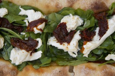 Gurme pizza dokusu ve deseni. Taze roka, İtalyan Burrata peyniri ve kurutulmuş domatesli pizza.. 