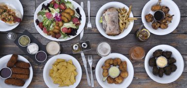 Lokantanın ahşap masasına serilmiş lezzetli yemek manzarası..