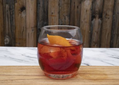 İçkiler. Cin, campari, kırmızı vermut, buz ve portakal kabuklu Negroni kokteylinin yakın görüntüsü..