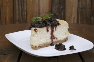 Tatlılar. Masanın üzerinde beyaz bir tabakta peynirli ve dutlu peynirli peynirli cheesecake 'in yakın görüntüsü.. 