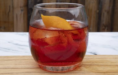 İçkiler. Cin, campari, kırmızı vermut, buz ve portakal kabuklu Negroni kokteylinin yakın görüntüsü..