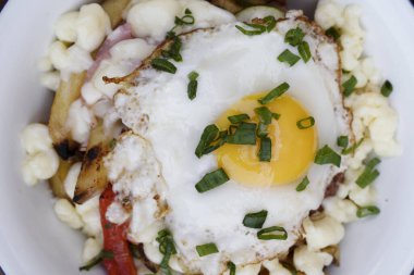 Gurme patates kızartması. Eritilmiş peynir, sucuk, dolmalık biber, soğan ve ahşap bir tabakta ızgara yumurta.. 