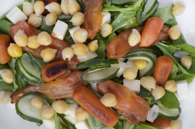 Sağlıklı yiyecekler. Bebek havuçlu taze salata, salatalık dilimleri, ızgara domates, nohut ve roka.. 