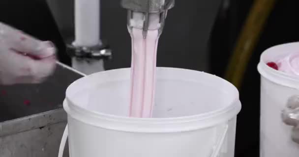 食品産業について アイスクリーム生産プロセス パイプから商業プラスチック容器に出てくるチェリーとクリームアイスクリームのクローズアップビュー 工場労働者は赤いチェリーを追加し プロセスを導きます — ストック動画