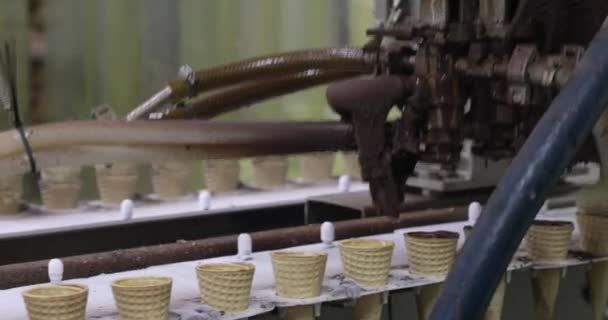 食品産業について オートメーションと製造 コーンにチョコレートを噴霧する電気機械のクローズアップビュー — ストック動画