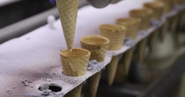 食品産業について 産業アイスクリーム工場ライン マシンにコーンを配置する手袋を持つオペレータのクローズアップビュー — ストック動画