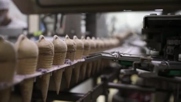 食品産業について チョコレートアイスクリームコルネットを輸送する電気機械のクローズアップビュー — ストック動画