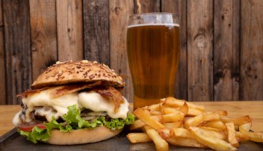 Danbo peynirli, marullu, domatesli, soğanlı, ızgara etli, kızarmış domuz pastırmalı ve patatesli, patates kızartmalı ve yarım litre biralı dev bir gurme burger..