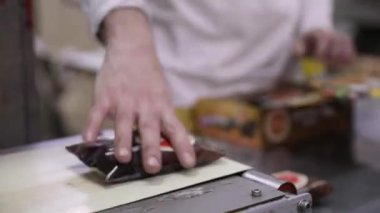 Yiyecek endüstrisi. Endüstriyel dondurma tatlısı bir taşıma bandı ile bir fabrika işçisine taşınıyor. Teslimat ve dağıtım için hazırlanıyor..