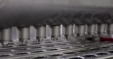 Endüstriyel dondurma üretimi ve üretimi. Teknoloji ve otomasyon. Buz kalıplarını çilek aromasıyla dolduran ticari buzlu dondurma üretim makinesinin yakın görüntüsü.