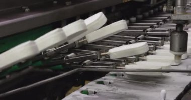 Yiyecek endüstrisi. Otomasyon ve teknoloji. Endüstriyel dondurma üretim süreci. Donmuş taşıma bandı boyunca dondurma taşıyan dondurma fabrikası makinesinin görüntüsü.