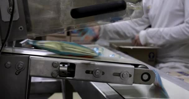 食品工业和技术 用塑料袋包裹冰淇淋冰棒的商业包装机的闭合视图 厂里的工人在背景音乐中打拳 — 图库视频影像