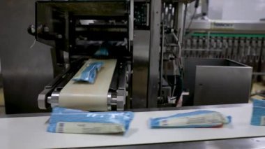 Gıda endüstrisi ve teknoloji. Dondurmaları plastik bir paketle paketleyen ticari bir ambalaj makinesinin yakın görüntüsü.