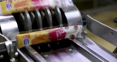 Yiyecek endüstrisi. Gıda üretiminde otomasyon ve teknoloji. Ticari çilek ve portakal aromalı buzlu dondurma taşıma bandı ürünü taşıyor..