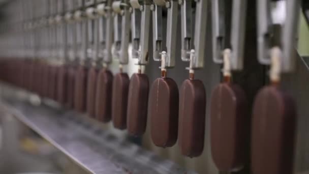 工业冰淇淋工厂 食品生产自动化和自动化技术 运送涂有巧克力的奶油棒棒糖的机器视图 — 图库视频影像