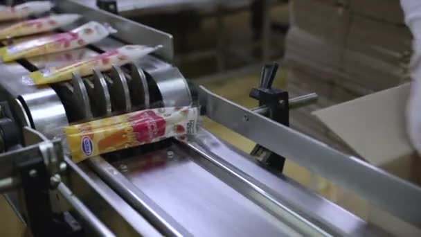 食品産業について 商業イチゴとオレンジ風味のポップスコンベアバンドは 製品を配達のためのアイスポップをボックスする工場労働者に製品を輸送 — ストック動画